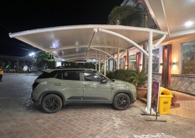 Tensile car parking structure with steel frame and weatherproof fabric canopy