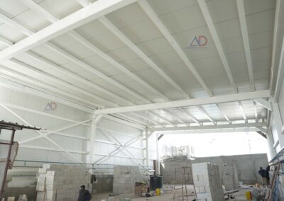 Commercial PEB steel structure with wide-span roofing by Amudha Decors