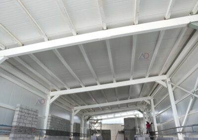Wide-span PEB roofing for manufacturing unit by Amudha Decors