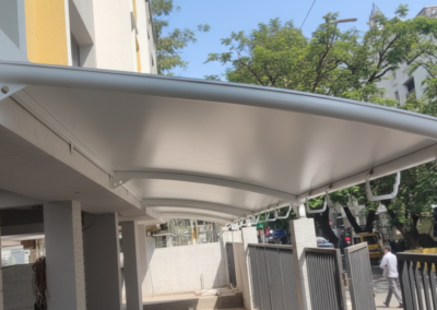 Curved entrance canopy roofing installed at K. K. Nagar for KCEE Properties by Amudha Decors