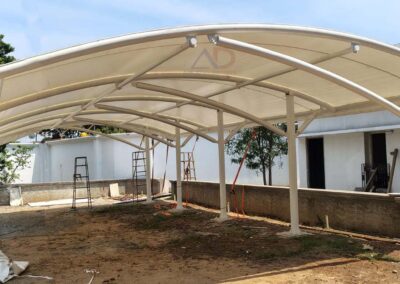 Side view of tensile car parking structure with steel columns and white membrane roofing