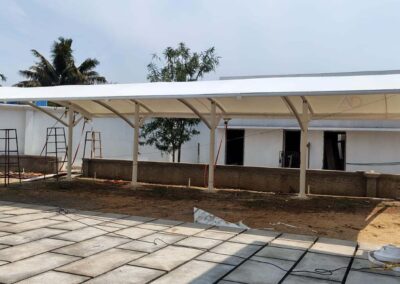 Top view of white tensile structure with curved membrane roofing installed for residential car parking
