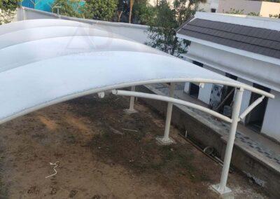 Front wide view of tensile fabric parking structure covering large area with curved design