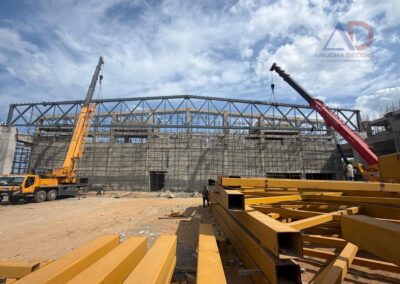 Pre Engineered Building (PEB) steel structure installation using cranes at an industrial construction site in Chennai by Amudha Decors.