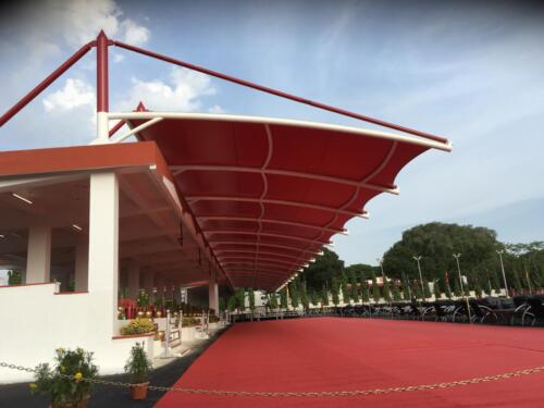 Modern tensile structure with a curved fabric canopy supported by steel cables.